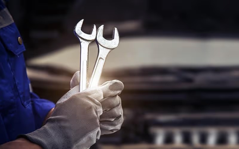 mechanic holding 2 wrenches during police vehicle repair near me