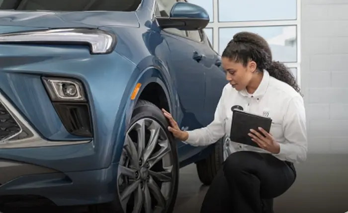 GM service tech inspecting a tire