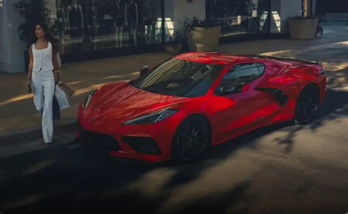 Woman approaching a Corvette parked on a city street