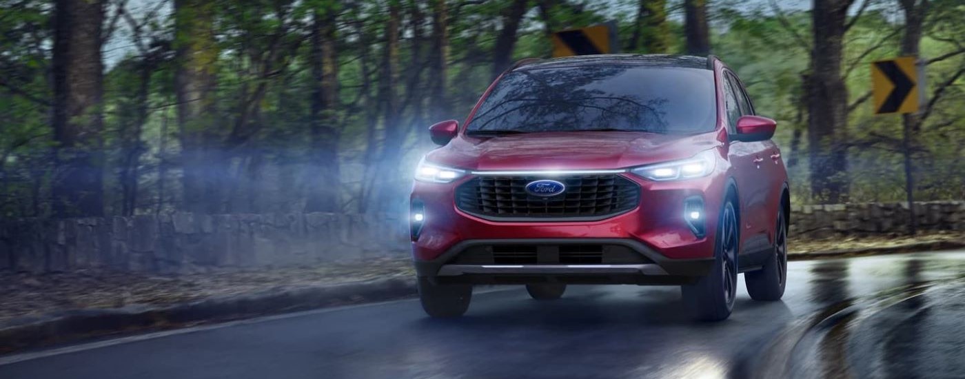 Red 2023 Ford Escape rounding a corner in the rain