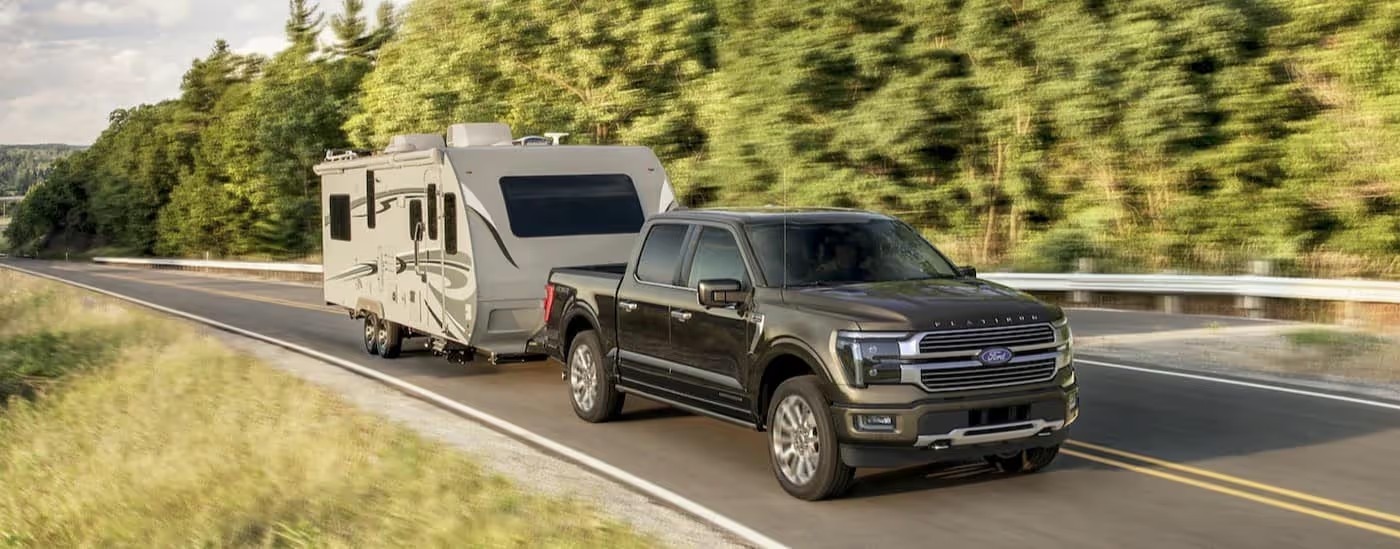 Borwn 2026 Ford F-150 Platinum towing a camper