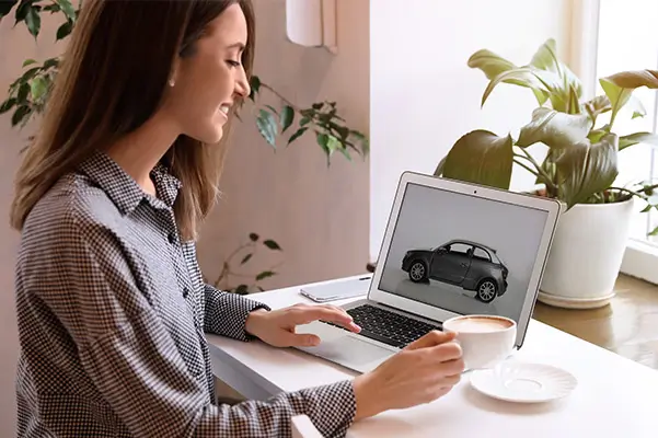 Woman choosing car using laptop, top view