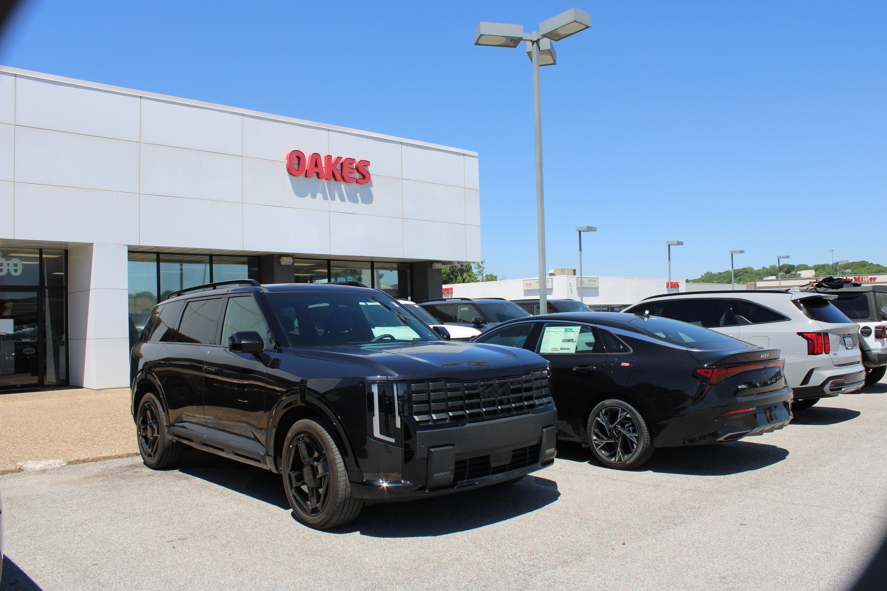 A black 2027 Kia Telluride in front of the Oakes sign at Oakes Kia in North Kansas City, MO.