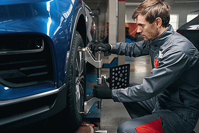 Technician tightening bolts on a car tire