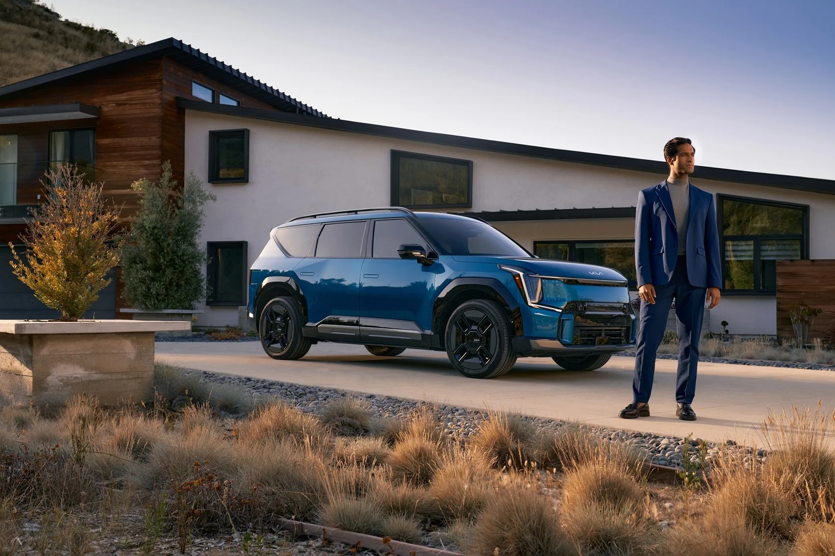 Blue Kia SUV in the driveway