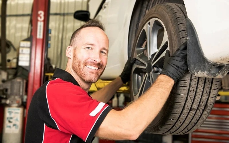 Smiling service tech working on tires