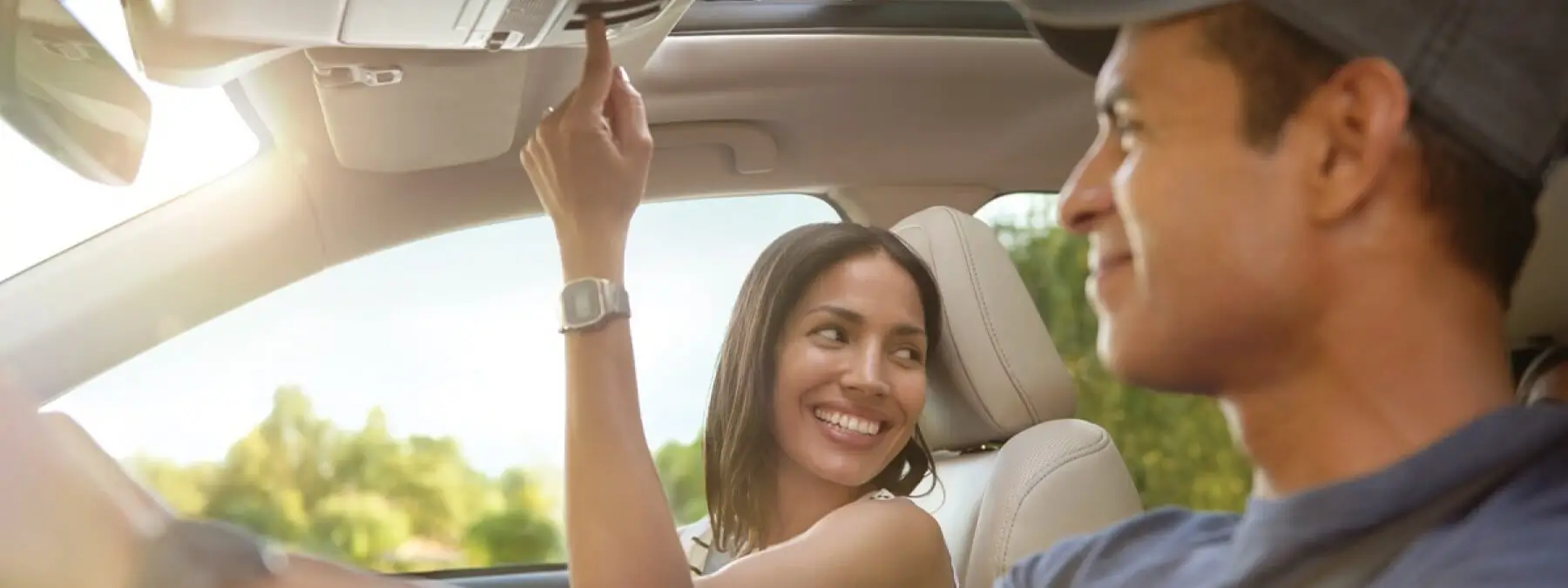 Hombre y mujer felices dentro de los asientos delanteros de un Subaru
